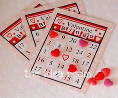 three valentine's day cards with hearts and candy on the table next to them