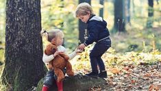 two children playing with stuffed animals in the woods