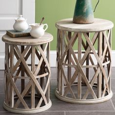 two tables with vases on top of them sitting next to each other in front of a green wall