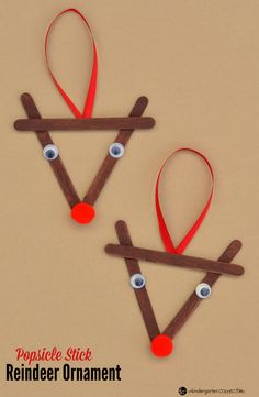 two reindeer ornament made out of sticks and yarn with eyes on them for christmas