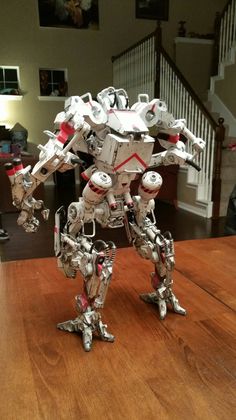 a toy robot standing on top of a wooden table