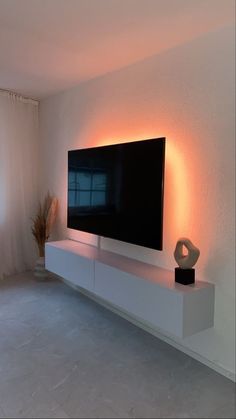 a flat screen tv sitting on top of a white entertainment center next to a window