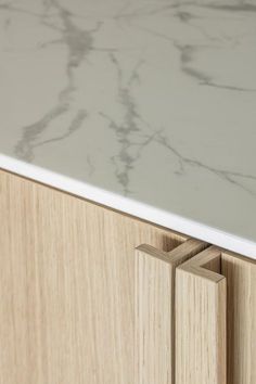 a marble counter top with two wooden handles on the front and back of each drawer