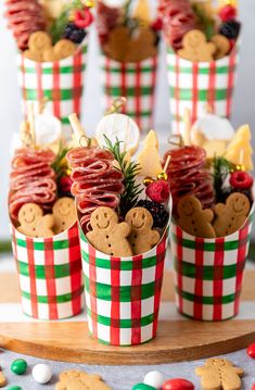 some cupcakes are decorated with cookies and candies in red, green and white paper cups