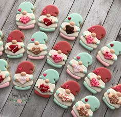 decorated cookies arranged in the shape of teddy bears with hearts on them, sitting on a wooden table