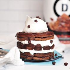 a stack of cake with whipped cream and chocolate chips