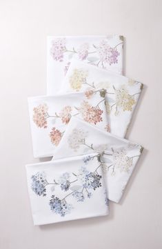 four napkins with flowers printed on them