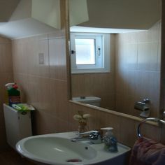 a bathroom sink sitting under a mirror next to a window