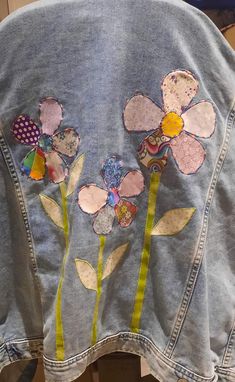 a denim jacket with flowers on the back