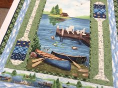 a quilted wall hanging with boats on the water