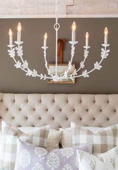 a chandelier hanging from the ceiling over a bed