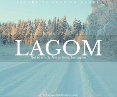 the words lagom are written in white on a snowy road surrounded by trees