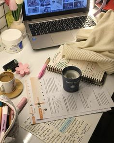 an open laptop computer sitting on top of a desk next to a cup of coffee