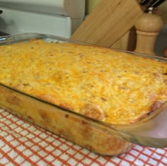 a casserole dish is sitting on a kitchen table with an orange and white checkered cloth