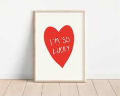 a red heart with the words i'm so lucky printed on it in white frame