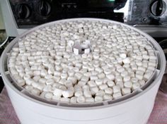 a large container filled with marshmallows sitting on top of a table next to an oven