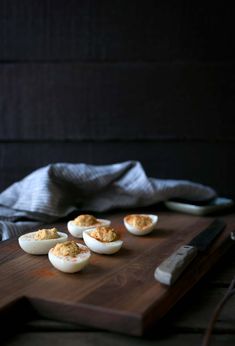 deviled eggs with crumbs on a cutting board