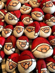 a bunch of rocks with santa clause faces on them, all decorated in red and white