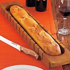 a loaf of bread sitting on top of a wooden cutting board next to a knife