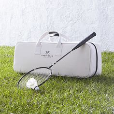 a tennis racquet and bag sitting in the grass