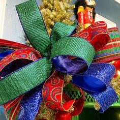 a christmas wreath with red, green and blue ribbons