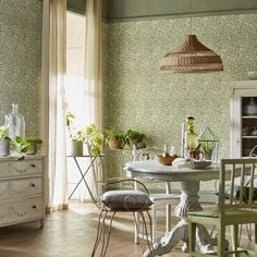 a table and chairs in a room with green wallpaper