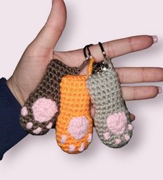 three small crocheted animal keychains in the palm of someone's hand