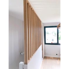 an empty room with wood slats on the wall and a window in the corner