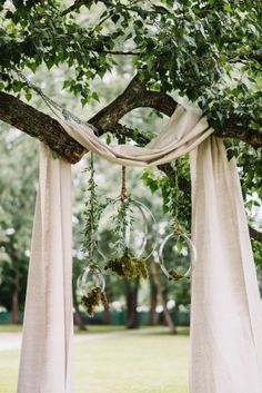 an outdoor wedding ceremony with hanging bubbles and greenery