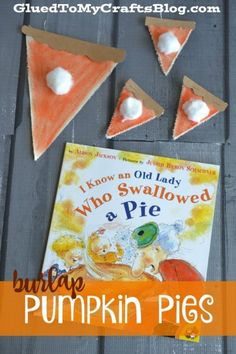 an orange and white book sitting on top of a table next to three pieces of paper