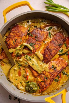 a pan filled with chicken and vegetables on top of a white counter next to green beans