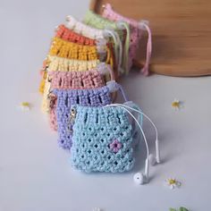 several crocheted purses sitting next to each other with ear buds in them