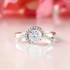 a white diamond ring sitting on top of a table