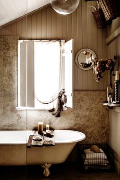 a bath tub sitting under a window in a bathroom