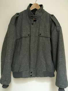 Manhattan men's XL gray bomber jacket with zip up, snaps and two pockets. Epaulets on shoulders. Made in USA. Condition is good without flaws, stains or tears. Zipper/snaps work well.  Material is not listed, but appears to be a wool blend. Insulated lining. Dry clean only. Measurements while lying flat pit to pit: 24" sleeve length from shoulder seam: 24 1/2" shoulder to shoulder back: 24" length from back base collar on down: 25 1/2" bottom width: 20" Non smoking home  Cleaned with Dryel and r Gray Winter Outerwear With Zip Fly, Grey Sport Coat, Sport Coat, Manhattan, Wool Blend, Made In Usa, Zip Ups, Bomber Jacket, Dry Clean