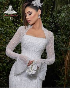 a woman wearing a white dress with flowers in her hair and holding a flower bouquet