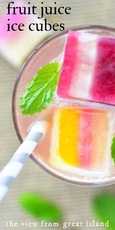 fruit juice ice cubes in a glass with a straw and mint on the side