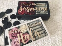 two black and white boxes with pink roses on them next to some fake hair clips