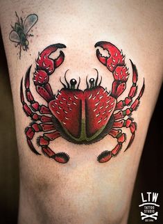 a crab tattoo on the side of a woman's leg