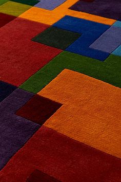 a multicolored area rug with squares and rectangles on the floor in various colors