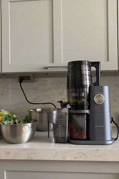 a blender sitting on top of a kitchen counter next to bowls and pans