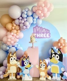 a birthday party with balloons, paper cutouts and cat figures in front of the cake