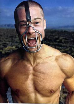 a man with no shirt on wearing a metal cage around his neck and nose mask