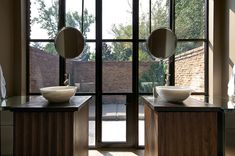 two bowls are sitting on the counter in front of glass doors that lead out to a courtyard