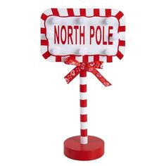 a red and white pole with a sign that says north pole on it's top