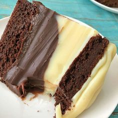 a piece of chocolate cake on a plate with white frosting and chocolate icing