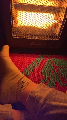 a person with their feet up in front of an oven