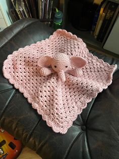 an elephant crocheted blanket sitting on top of a leather chair