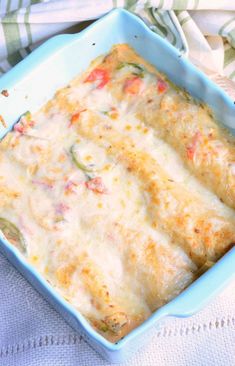 a casserole dish with cheese and vegetables in it sitting on a white towel