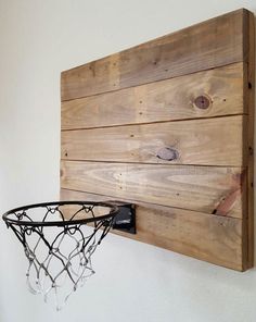 a basketball hoop mounted to the side of a wooden wall hanging on a white wall